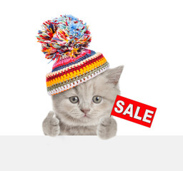 Poster - Kitten wearing warm winter hat shows signboard with labeled 