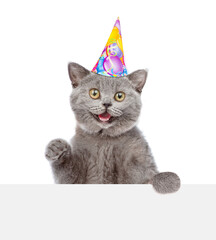 Poster - Surprised cat wearing party's cap look above blank white banner. isolated on white background