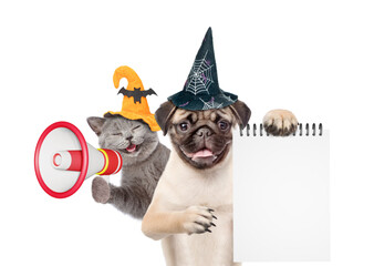 Fototapete - Happy cat and Pug puppy wearing  hats for halloween looks at camera. Dog holds blank notepad. Kitten meowing into the megaphone. isolated on white background