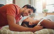© peopleimages.com - Love, laugh and happy couple on floor in home for connection, bonding or relax with partner on cushions. Living room, man and woman with funny joke, comedy and communication for relationship together