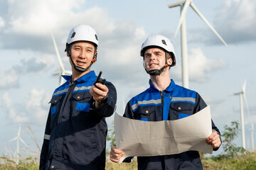 Diverse ethnicity male technicians working in the wind turbines field.