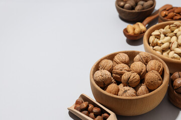 Wall Mural - Various nuts in wooden bowls on a gray background