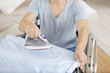 © auremar - cropped view of handicapped man ironing a shirt