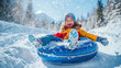 © ЮРИЙ ПОЗДНИКОВ - Happy child sliding down snowy hill on snow tube, enjoying winter fun