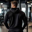 © Tadeusz - Back view of a muscular Caucasian man in a black hoodie at the gym.