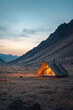 © stanhert - A tent is set up in a desert-like environment at sunset