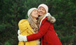 © rohappy - Happy smiling mature mother and adult daughter hugs in winter forest, Christmas tree with snow