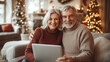 © D-stock photo - Happy senior couple using digital tablet and smiling at camera while sitting on sofa at home
