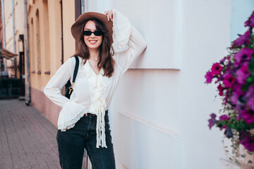 portrait of young beautiful smiling hipster woman in trendy summer white blouse and jeans. carefree 