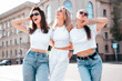 © halayalex - Three young beautiful smiling hipster female in trendy summer white t-shirt  and jeans clothes. Sexy carefree women posing in the street. Positive models having fun, going crazy. In sunny day, eyewear