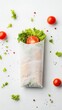 © Sasa Visual - A sandwich wrapper mockup on a white backdrop surrounded by fresh tomatoes and crisp lettuce