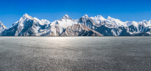 Wall Mural - asphalt road square and snow mountain natural landscape under blue sky. car background.