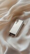 © Sasa Visual - A brushed aluminum USB drive is elegantly displayed on a light fabric backdrop