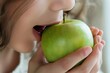 © Alla - A young girl taking a bite of a juicy apple, enjoying the sweetness