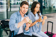 © Iryna - Young couple enjoying a healthy snack outdoors at modern venue. Young couple, man and woman, enjoying a healthy snack outdoors at modern venue, at airport terminal outdoor.