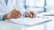 © Tondone - Close-up of a medical professional writing on a report, showcasing precision and attention to detail in a clinical setting.