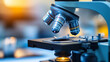 © Sawyer0 - Mikroskop, który skupia się na szkiełku z próbką biologiczną. Zbliżenie pokazuje detale próbki, które są niewidoczne gołym okiem.
