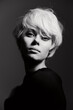 © SHOTPRIME STUDIO - Elegant young woman with short blonde hair, posing confidently in a dark setting, exuding a mysterious and artistic vibe through her thoughtful expression.
