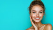 © ELENA - Model smiling while touching her flawless glowy skin with a lot of copy space for text, blue background