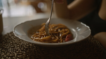 Poster - A woman enjoys a delicious plate of pasta in an indoor italian restaurant in italy, showcasing authentic cuisine and cozy dining experience on a woven mat.