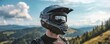 © Prichachai - Mountain biker wearing a helmet, gazing at scenic landscape with hills and blue sky, emphasizing adventure and outdoor exploration.