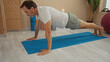 © Krakenimages.com - Mature hispanic man exercises indoors on blue yoga mat at wellness center demonstrating fitness and balance in serene spa setting focused on health and relaxation.