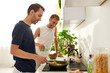 © Bliss - Two men happily collaborate in a bright kitchen, cooking and smiling at home