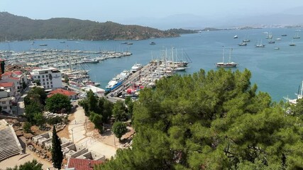 Wall Mural - Aerial view of greenery and the port with boats in the sea in  Fethiye Turkey on a sunny day