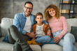 © Miljan Živković - portrait of mother, father and son while sit on sofa together