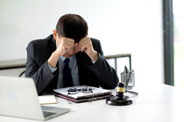 Wall Mural - A lawyer is stressed while sitting at a desk at a law firm giving the appearance