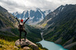 © Павел Чигирь - A tourist girl stands on a stone overlooking the beautiful mountains and Lake Shavlinskoye. Altai. Siberia