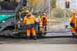 © Darya - Workers lay new asphalt on a road using an asphalt paver