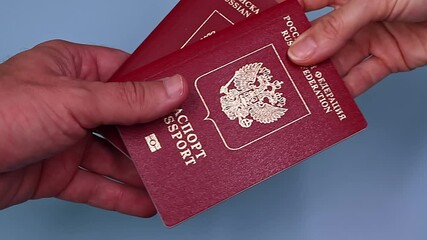 Wall Mural - Slow motion video. Close up view of hands holding russian passport. Russian translation - Russian Federation. Passport.