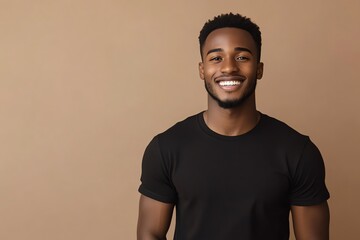 Wall Mural - A handsome young man in a plain black T-shirt poses confidently under studio lights with a clean white background.