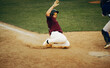 © Jacob Lund - Baseball player slides into home plate, creating a cloud of dust during a competitive game