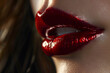 © EliteStock - Close-up of plump lips with glossy red lipstick, emphasizing sensuality and elegance against a dark background.