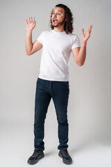 young man with curly hair expresses surprise in a light-colored setting