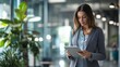 © Bold24 - A professional woman reviewing data on a tablet in a modern office