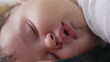 © Marco - Baby sleeping peacefully with lips slightly parted and tear near eye, close-up showing soft details of the face, gentle moisture visible on the lips and serene expression during deep sleep