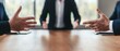 © Naphol - Business meeting with hands gesturing over a wooden table, showcasing communication and negotiation.