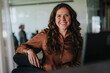 © Maskot - Portrait of happy mature businesswoman with brown hair in office