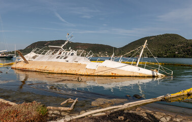 A half submerged sunken boat in shallow water.