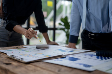 Two people are looking at a table with graphs and charts