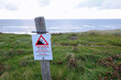 © ChiccoDodiFC - warning sign in danish and english about danger of falling and collapsing cliff by sea