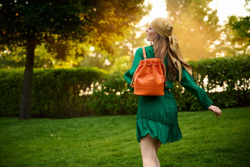 happy girl model in a green dress in the park. Fashion outdoor shooting.