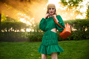 happy girl model in a green dress in the park. Fashion outdoor shooting.