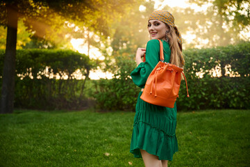 happy girl model in a green dress in the park. Fashion outdoor shooting.