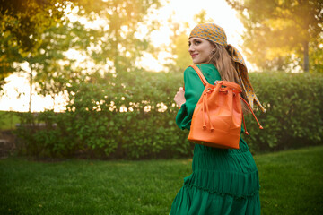 happy girl model in a green dress in the park. Fashion outdoor shooting.