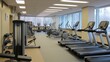 © Chatchanan - Office building gym filled with exercise equipment,