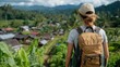 © Lens Legacy - A traveler wearing a backpack takes in the breathtaking view of a lush green hillside village with scattered rustic houses surrounded by nature's beauty.